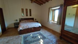 Schlafzimmer mit einem Bett und einem Fenster in der Unterkunft Podere Cerrete - Eco Farmhouse in Castel del Piano