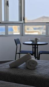 ein Handtuch auf einem Bett mit einem Tisch und Stühlen in der Unterkunft Chez Frois in Las Palmas de Gran Canaria