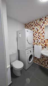 ein Badezimmer mit einem WC und einer Waschmaschine in der Unterkunft Chez Frois in Las Palmas de Gran Canaria