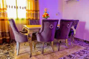 a dining room with purple chairs and a table at RESIDENCE LINO LE BENGUISTE in Yaoundé