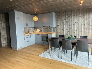 a kitchen and dining room with a table and chairs at Ny leilighet på Norefjell - ski in/out in Noresund