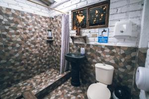a bathroom with a toilet and a shower with a sink at Campo Wasi in Riobamba