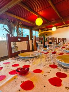 una mesa con copas de vino y flores rojas. en Domaine de l'Anse en Petite Île