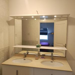 een badkamer met 2 wastafels en een grote spiegel bij le calme de la campagne bretonne, wifi, netflix, 4 lits, freebox revolution, draps, café, thé in Guer