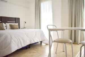 um quarto com uma cama, uma mesa e uma cadeira em La Gioconda Apart Hotel em Villa María