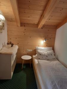 a small room with two beds and a table at Haus Gmahblick Appartments in Alpbach