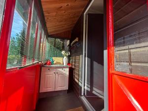 Zimmer mit einer roten Tür und einem Fenster in der Unterkunft Cottage tres bien équipé avec jacuzzi 
