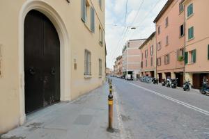 een lege straat met een zwarte deur en een paal bij MONO Apartments Saragozza in Bologna