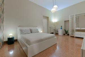een witte slaapkamer met een bed en een bureau bij MONO Apartments Saragozza in Bologna