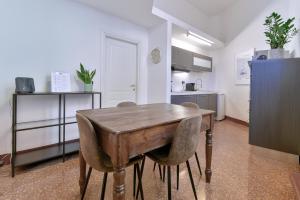 een keuken met een houten tafel en een aantal stoelen bij MONO Apartments Saragozza in Bologna