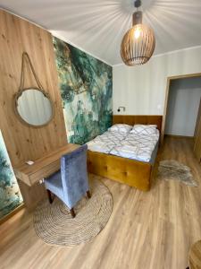 um quarto com uma cama, um espelho e uma cadeira em Apartamenty Białe nad jeziorem Białym em Augustów