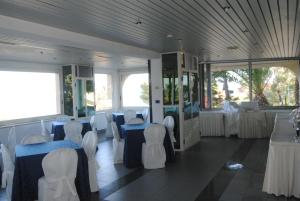 pokój ze stołami i białymi krzesłami oraz pokój ze stołami w obiekcie Helios Hotel w mieście Crotone