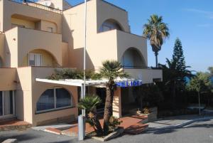 Un edificio con palmeras delante. en Helios Hotel, en Crotone
