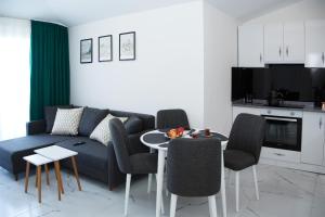 uma sala de estar com um sofá, uma mesa e cadeiras em ArtLife apartments (VAN GOGH) em Alanya