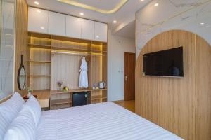 um quarto com uma cama grande e uma televisão em Mint Hoi An Villa em Hoi An