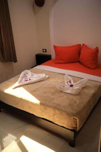 Una cama con dos cuencos encima. en Kana Kato en Asuán