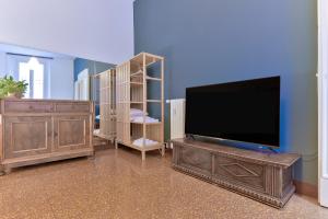 een woonkamer met een flatscreen-tv en een houten entertainmentcentrum bij MONO Apartments Saragozza in Bologna