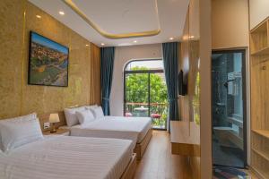 una camera d'albergo con due letti e una finestra di Mint Hoi An Villa a Hoi An