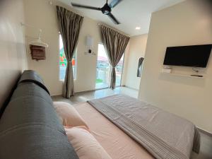 a living room with a couch and a flat screen tv at AA SWEET ROOM TANJUNG BIDARA MELAKA in Masjid Tanah