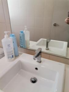 een wastafel in de badkamer met 2 flessen zeep en een spiegel bij I-Suite Block B [2r2b] # I-City [ Free Wifi + Parking ] in Shah Alam