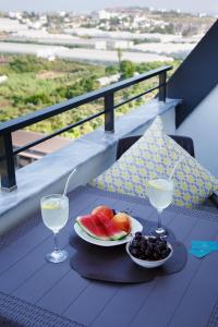 une table avec une assiette de fruits et deux verres à vin dans l'établissement ArtLife apartments (VAN GOGH), à Alanya