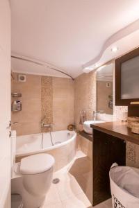 ein Badezimmer mit einer Badewanne, einem WC und einem Waschbecken in der Unterkunft Modern and Warm Downtown in Athen