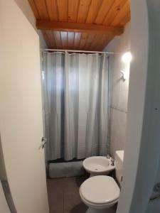 uma casa de banho com um WC branco e um chuveiro em Casa con jardín - Circuito Chico, Bariloche em San Carlos de Bariloche
