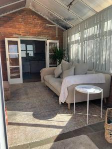 a living room with a couch and a table at Rose Cottage Glastonbury in Glastonbury