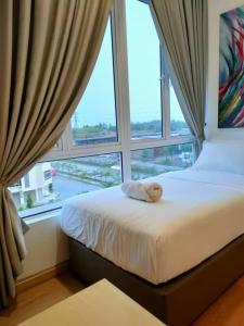 a bed in a room with a large window at Husfa Mahkota Valley Studio Suite in Kuantan