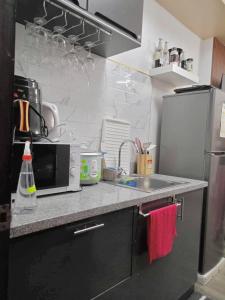 a kitchen counter with a sink and a microwave at Spacious Combine Family Unit Condo at Mesaverte Residences downtown near SM Gaisano Robinson and Centrio in Cagayan de Oro