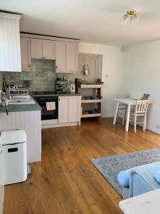 una cucina con armadietti bianchi e pavimenti in legno di Rose Cottage Glastonbury a Glastonbury