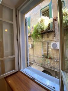 a window with a view of a building at PM 2 Via Scano Guest House B in Sassari