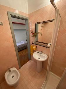 a bathroom with a sink and a toilet and a mirror at PM 2 Via Scano Guest House B in Sassari
