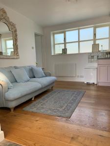 ein Wohnzimmer mit einem Sofa und einem Teppich in der Unterkunft Rose Cottage Glastonbury in Glastonbury