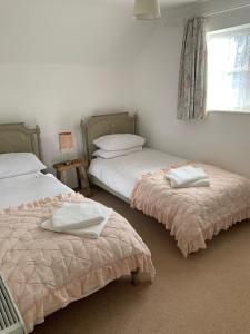 1 dormitorio con 2 camas y ventana en Rose Cottage Glastonbury en Glastonbury