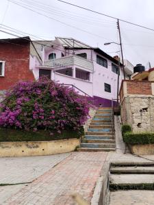 una casa con flores púrpuras y escaleras delante en Casa Lila, en Mineral del Monte