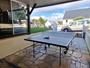 - une table de ping-pong assise sur une terrasse dans l'établissement Comfortable holiday home with garden in quiet location, Binic, à Binic