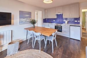a kitchen with a wooden table and white cabinets at South Bay Garden Apartment in Scarborough