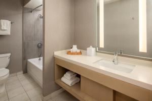 uma casa de banho com um lavatório, um WC e um espelho. em Hotel Paradox, Autograph Collection em Santa Cruz