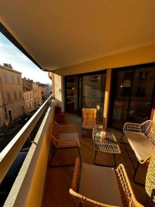 - un balcon avec des chaises et des tables dans un bâtiment dans l'établissement Pepite Coeur 7ème Tout Confort - Clim - Parking, à Marseille