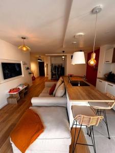 a living room with a white couch and a kitchen at Pepite Coeur 7ème Tout Confort - Clim - Parking in Marseille