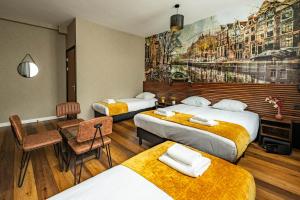 a hotel room with two beds and a table and chairs at Historic Centre Hotel in Amsterdam