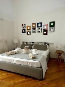ein Schlafzimmer mit einem großen Bett mit Bildern an der Wand in der Unterkunft Bijoux Luxury Apartment in Old Town in Bari