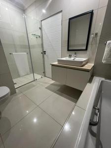 a bathroom with a sink and a shower and a toilet at Seaview Sanctuary in Durban