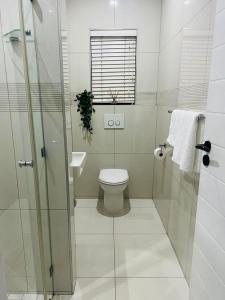 a white bathroom with a toilet and a sink at Seaview Sanctuary in Durban