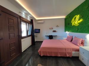 a bedroom with a pink bed and a green wall at THEASIS 4 luxury studio with sea view in Neos Marmaras