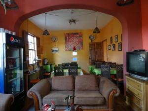 sala de estar con sofá y TV en Hostal del Piamonte, en Quito