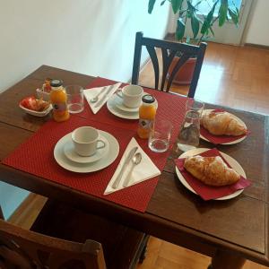 una mesa de madera con alimentos para el desayuno y bebidas. en B&B Velocipede, en Cervignano del Friuli