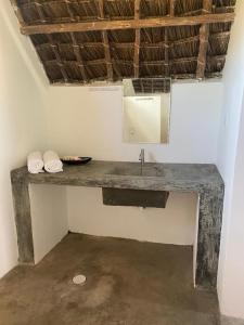 a bathroom with a sink in a room at Kokopelli Bungalows in Nungwi