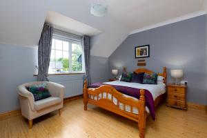 a bedroom with a bed and a chair and a window at Michaeleen's Manor B&B in Cong